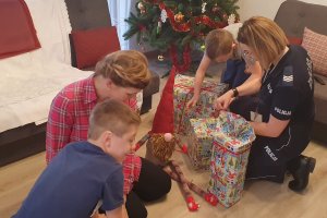 policjantka wraz z dziećmi rozpakowuje prezenty