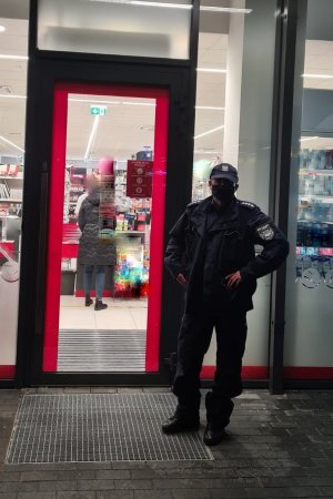 policjant stojący przed wejściem do jednego z chełmińskich sklepów