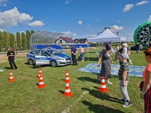 policyjny radiowóz stoi na boisku w trakcie pikniku rodzinnego