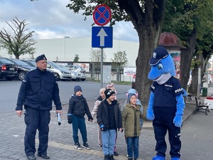 Polfin i policjant stoją z dziećmi