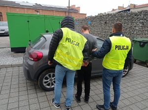 policjanci trzymają zatrzymanego mężczyznę