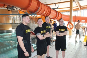 uczestnicy zawodów stoją przy basenie