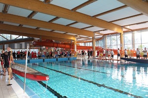 uczestnicy zawodów stoja wokół basenu
