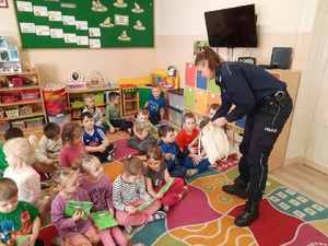 policjantka wręcza dzieciom kamizelki odblaskowe