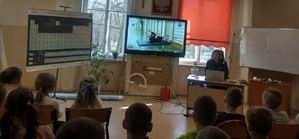 dzieci oglądają wyświetlany na monitorze film